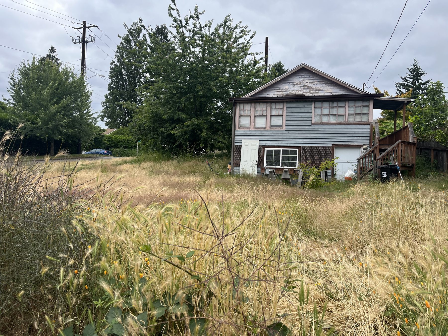 A weathered, vacant-looking house with peeling paint and an overgrown yard, the kind of physical distress that shows up in code-violation records before a pre-foreclosure filing hits the county.